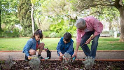A grandparent with her grandchildren in the garden