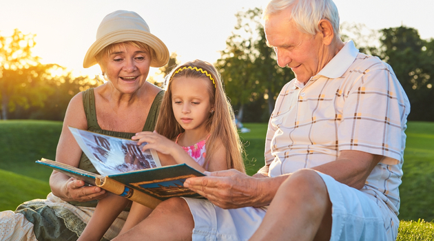 grandparents granddaughter looking at photo album