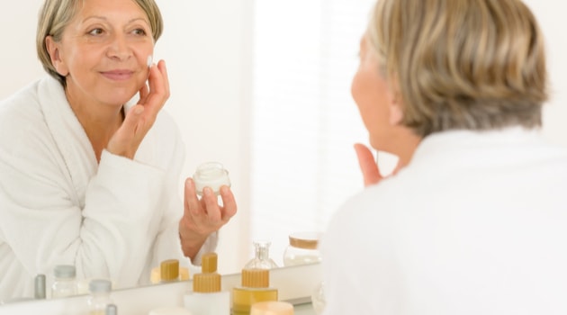 senior woman bathroom mirror skincare routine