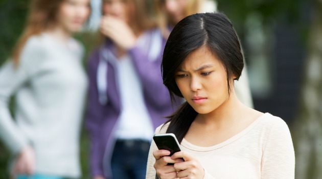 girl on phone being cyberbullied
